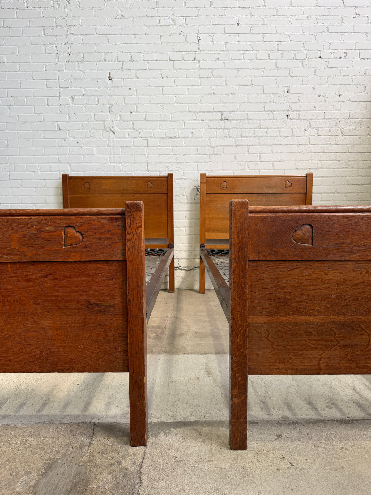 A Pair of Edwardian Heart Motif Beds by Liberty of London